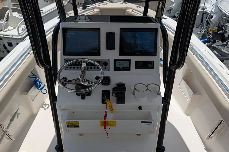 Slide: The Image of 2024 Key West 239 FS boat dashboard with steering wheel and navigation screens. - 15