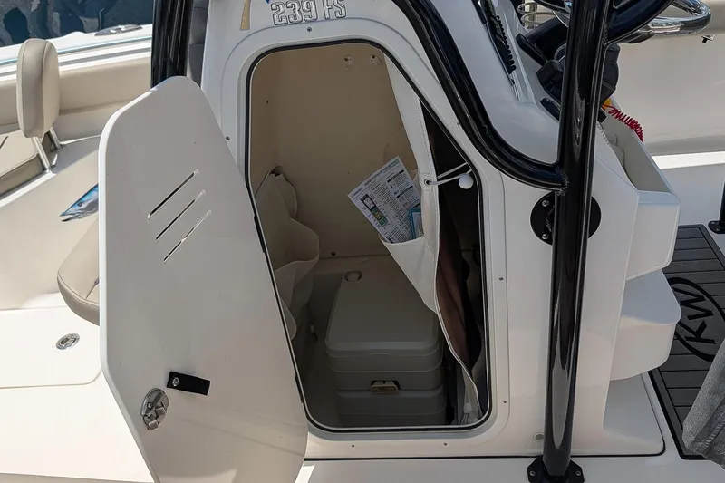 Slide: The Image of 2024 Key West 239 FS boat storage compartment with open door and interior view. - 16