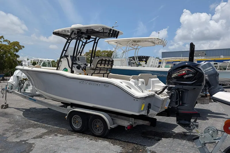 Slide: The Image of 2024 Key West 239 FS boat on trailer with Yamaha engine, parked outdoors. - 2