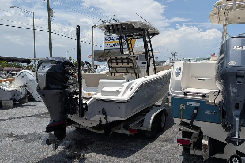 Slide: The Image of 2024 Key West 239 FS boat on trailer at marina, Yamaha engine visible. - 4
