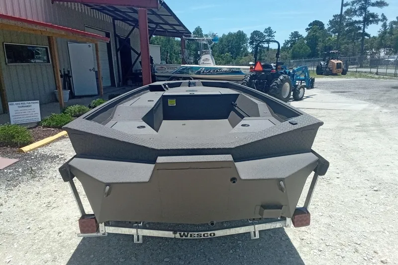 Slide: The Image of 2026 Alweld 1548 Invader boat on trailer, outdoor setting with equipment in background. - 8