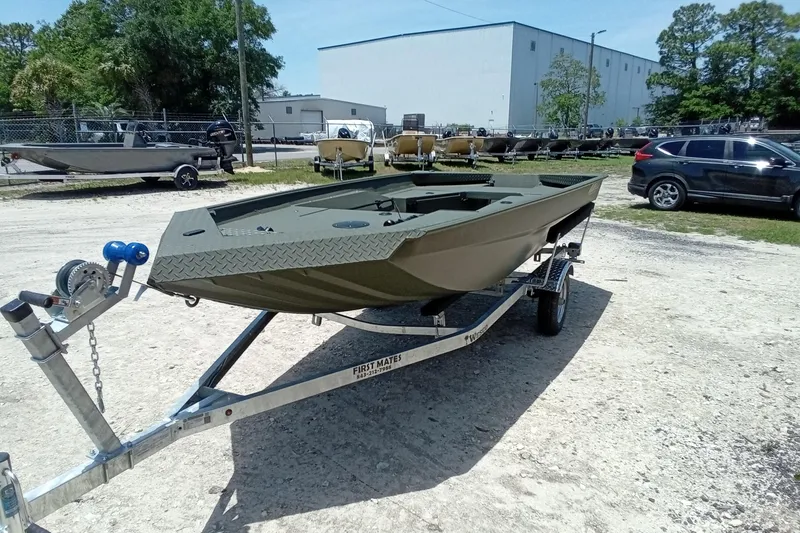 Slide: The Image of 2026 Alweld 1548 Invader boat on trailer, parked outdoors near industrial building. - 14