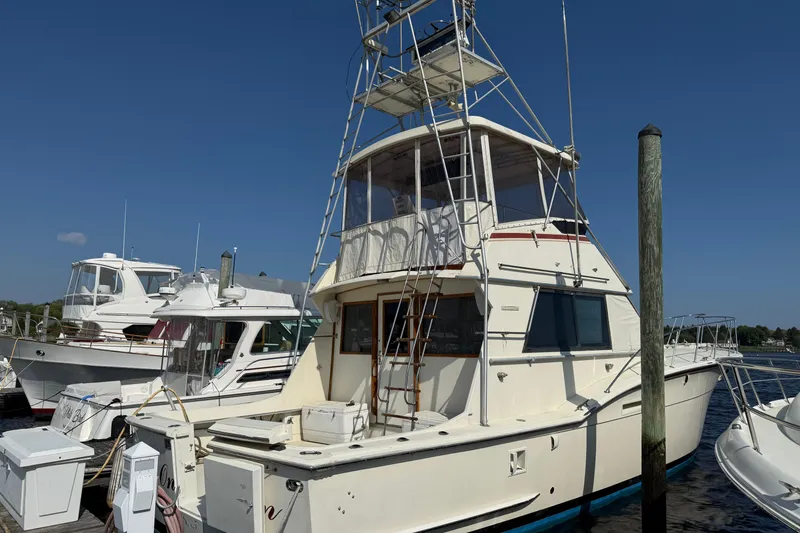 Slide: The Image of 1979 Hatteras 46 Convertible yacht docked at marina under clear blue sky. - 1