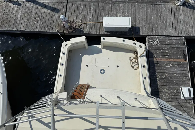 Slide: The Image of Aerial view of 1979 Hatteras 46 Convertible yacht docked at a wooden pier. - 13