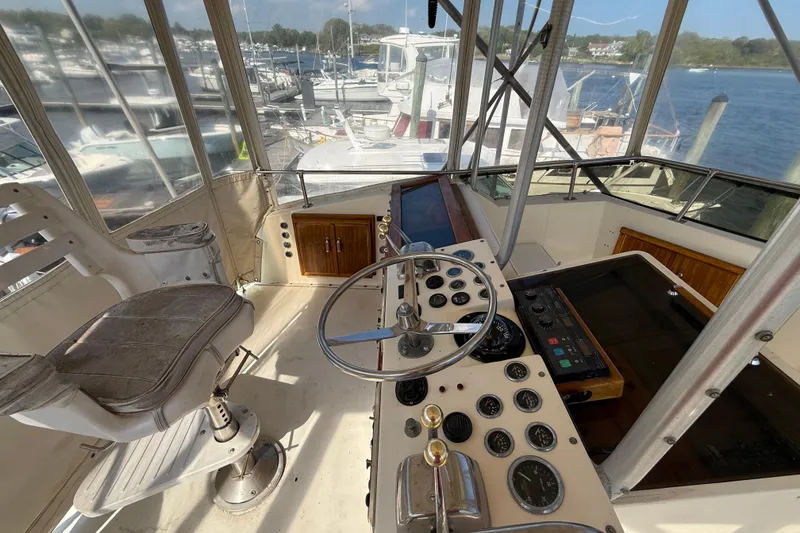 Slide: The Image of 1979 Hatteras 46 Convertible yacht helm with steering wheel and control panel. - 14