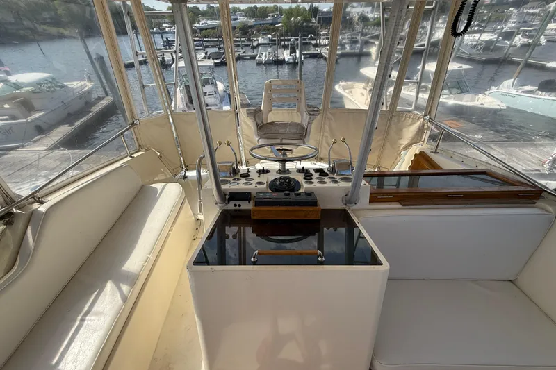 Slide: The Image of Interior view of 1979 Hatteras 46 Convertible yacht helm with marina background. - 16