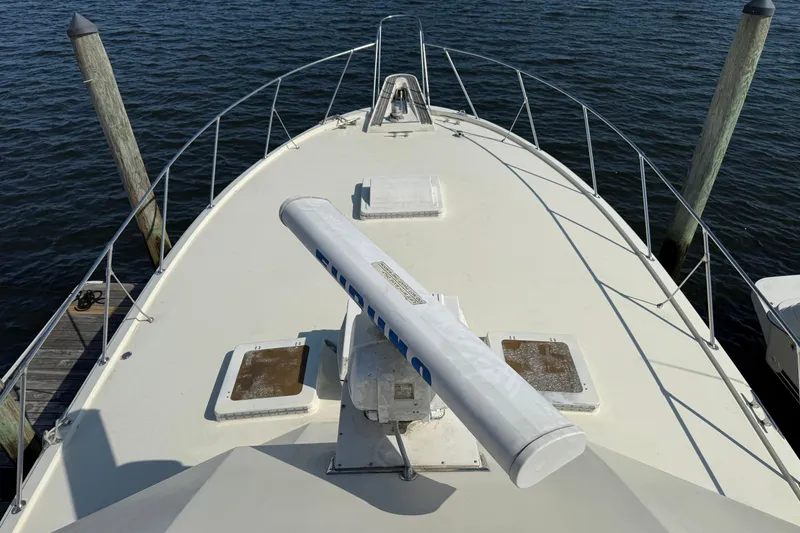 Slide: The Image of Bow view of 1979 Hatteras 46 Convertible yacht docked by wooden posts. - 17
