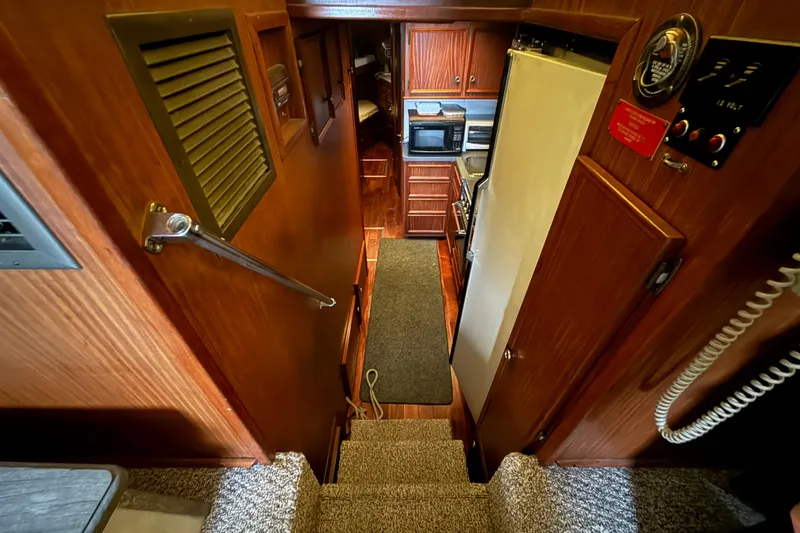 Slide: The Image of Interior view of 1979 Hatteras 46 Convertible yacht, featuring wooden cabinetry and kitchen area. - 24