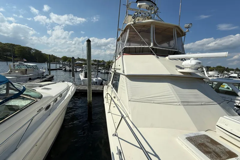 Slide: The Image of 1979 Hatteras 46 Convertible yacht docked at marina under blue sky. - 3