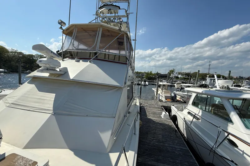 Slide: The Image of 1979 Hatteras 46 Convertible yacht docked at marina under clear blue sky. - 4