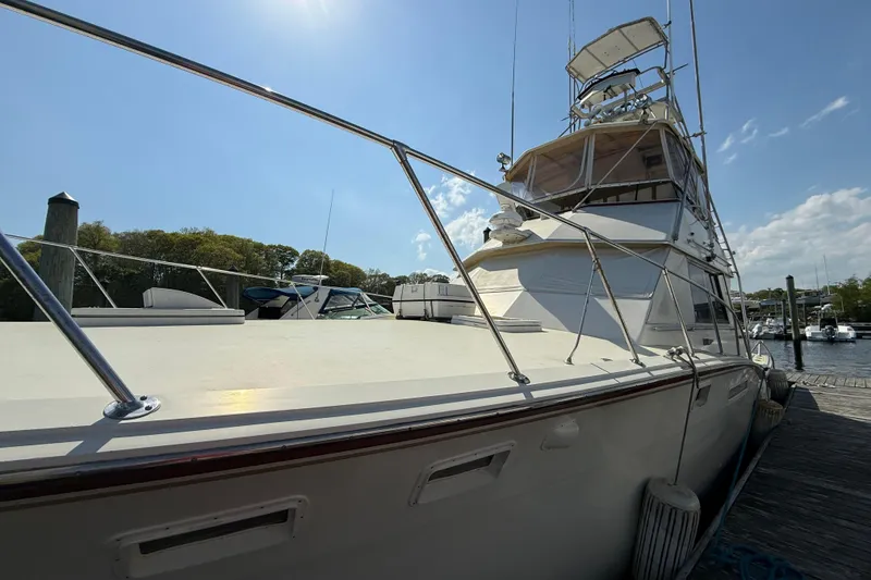 Slide: The Image of 1979 Hatteras 46 Convertible yacht docked under clear blue sky. - 5