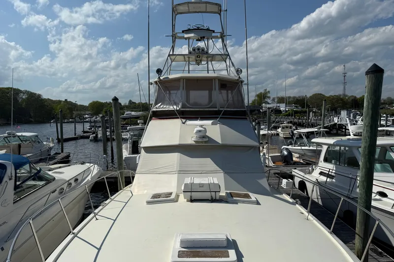 Slide: The Image of 1979 Hatteras 46 Convertible yacht docked at marina under blue sky. - 6