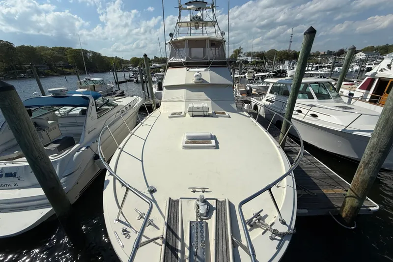 Slide: The Image of 1979 Hatteras 46 Convertible yacht docked at a marina under a partly cloudy sky. - 7