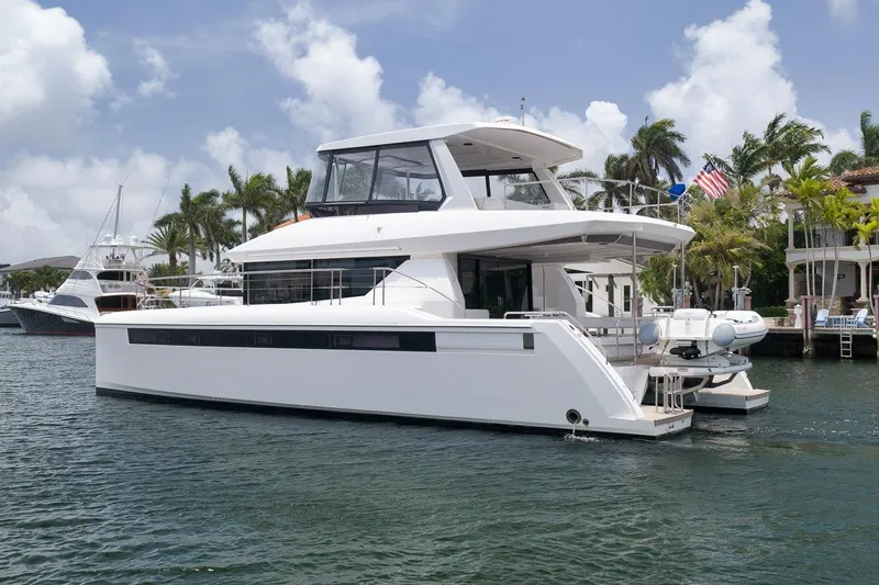 Slide: The Image of 2024 Leopard 46 Powercat yacht docked in a tropical marina setting. - 1