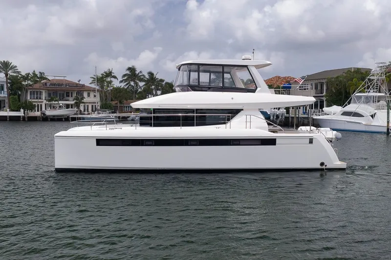 Slide: The Image of 2024 Leopard 46 Powercat yacht on calm water, with luxury homes in the background. - 10
