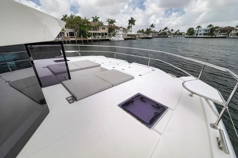 Slide: The Image of 2024 Leopard 46 Powercat deck with sun loungers, overlooking waterfront homes and palm trees. - 23