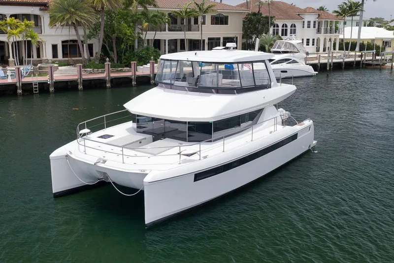 Slide: The Image of 2024 Leopard 46 Powercat yacht docked near waterfront homes. - 4