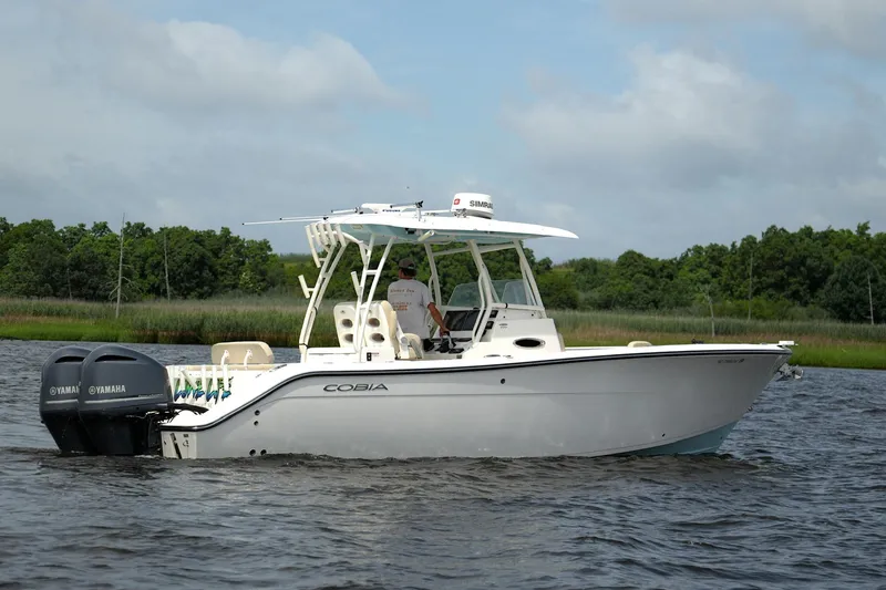 Slide: The Image of 2016 Cobia 296 Center Console boat on water with dual Yamaha engines. - 13