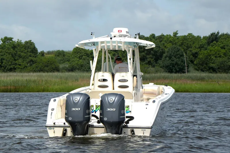 Slide: The Image of 2016 Cobia 296 Center Console boat cruising on a scenic waterway. - 14