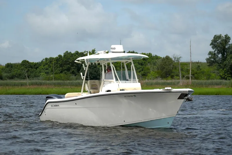 Slide: The Image of 2016 Cobia 296 Center Console boat cruising on a scenic waterway. - 4