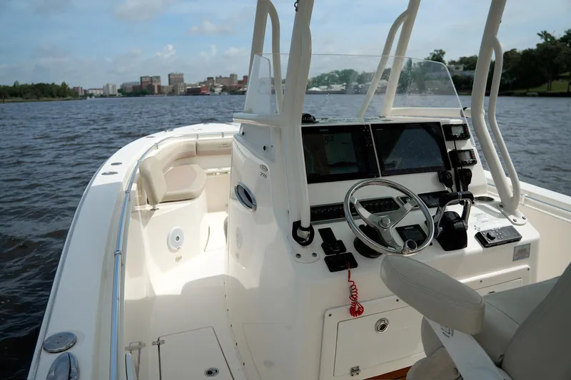 Slide: The Image of 2016 Cobia 296 Center Console boat on water, featuring helm and seating area. - 6
