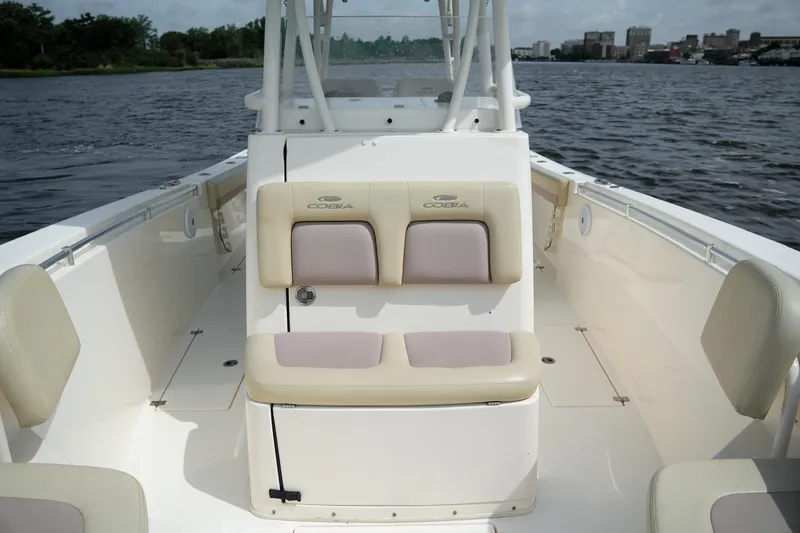Slide: The Image of 2016 Cobia 296 Center Console boat interior with cushioned seating on calm water. - 8