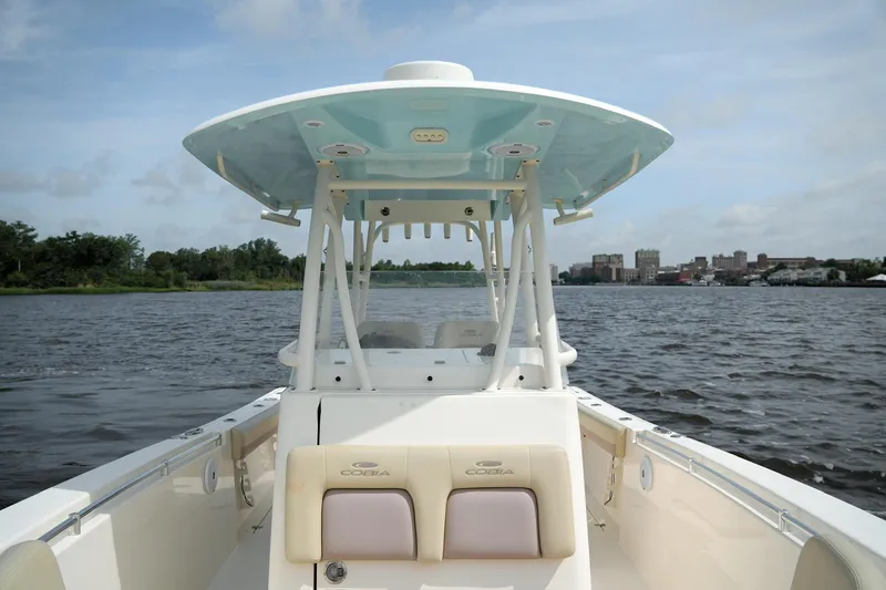 Slide: The Image of 2016 Cobia 296 Center Console boat on calm water with cityscape background. - 9