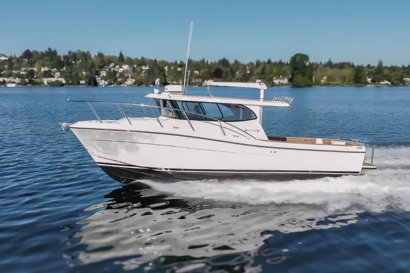 The Image of 2025 Ocean Sport Roamer cruising on a serene lake under a clear blue sky. - 0