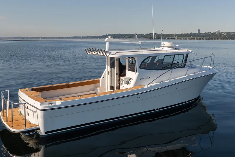 Slide: The Image of 2025 Ocean Sport Roamer boat on calm water, showcasing sleek design and spacious deck. - 10