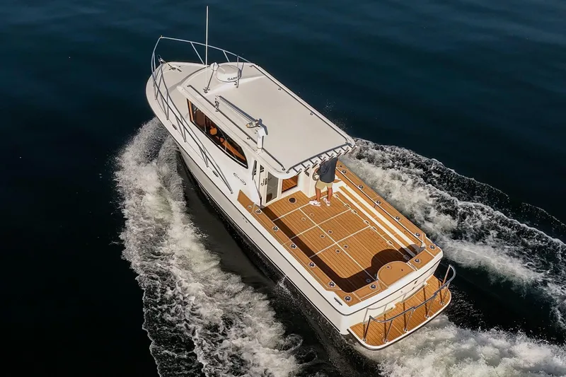Slide: The Image of 2025 Ocean Sport Roamer cruising on open water, showcasing sleek design and wooden deck. - 11