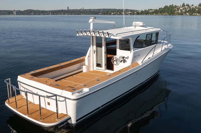 Slide: The Image of 2025 Ocean Sport Roamer boat on calm water, featuring sleek design and spacious deck. - 12
