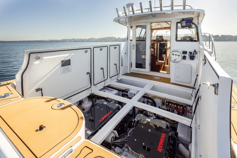 Slide: The Image of 2025 Ocean Sport Roamer boat with open engine compartment, showcasing Yanmar engines on a sunny day. - 17