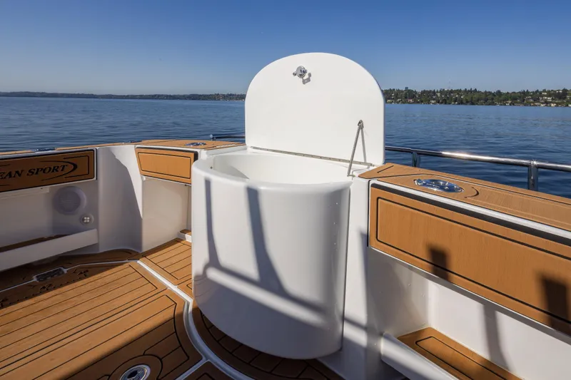 Slide: The Image of 2025 Ocean Sport Roamer boat deck with wooden flooring and built-in sink. - 19