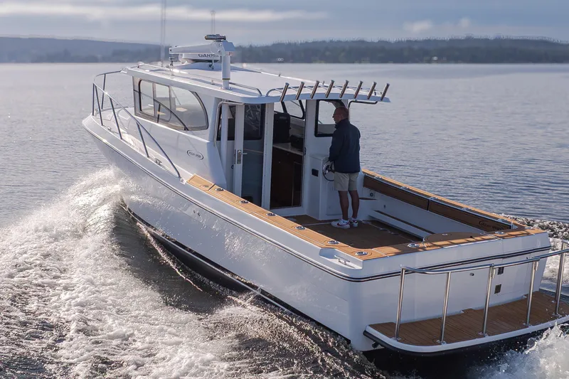 Slide: The Image of 2025 Ocean Sport Roamer boat cruising on calm waters with a person at the helm. - 2