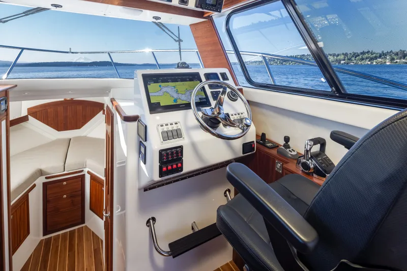 Slide: The Image of 2025 Ocean Sport Roamer helm with navigation system, luxurious interior, and scenic ocean view. - 23