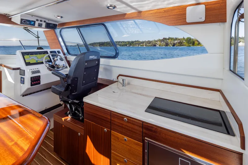 Slide: The Image of Interior of 2025 Ocean Sport Roamer boat with helm, navigation system, and kitchenette. - 25