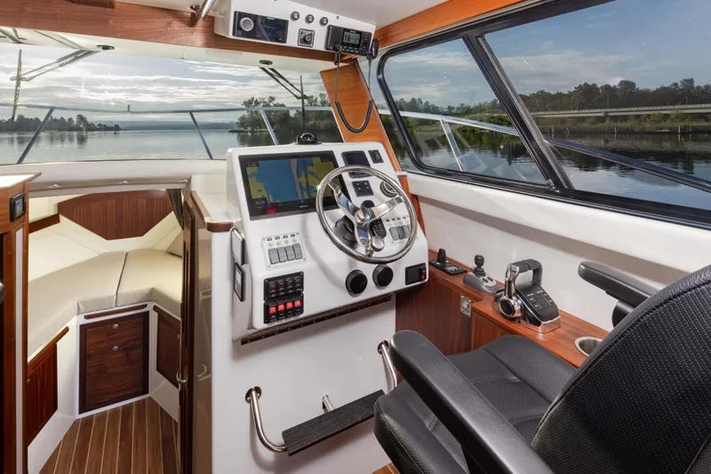 Slide: The Image of Interior of 2025 Ocean Sport Roamer boat with modern navigation equipment and scenic water view. - 26
