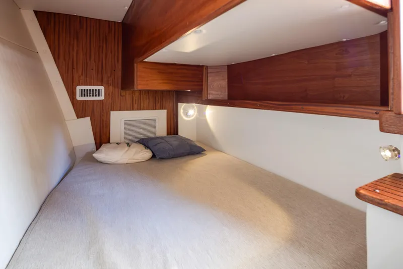 Slide: The Image of 2025 Ocean Sport Roamer cabin interior with cozy bed and wooden accents. - 30