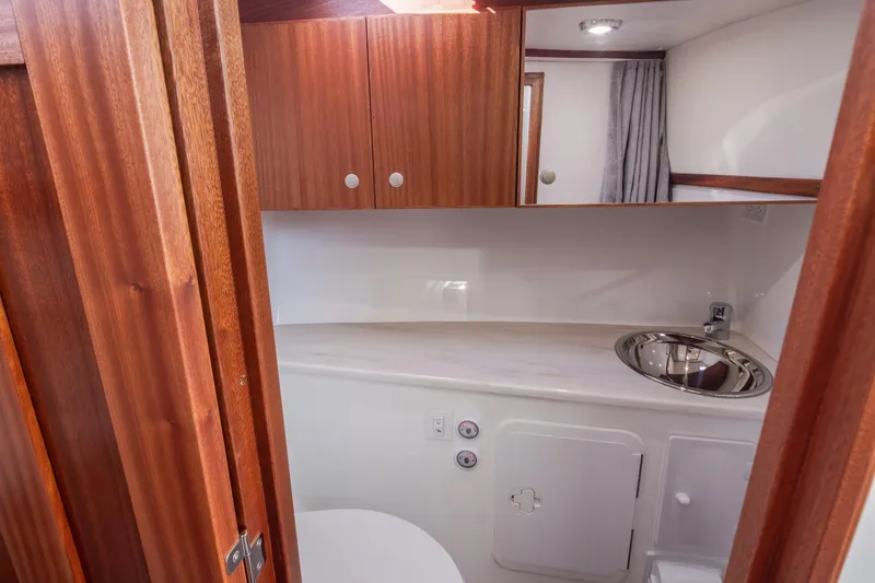Slide: The Image of 2025 Ocean Sport Roamer yacht bathroom with wooden cabinets and modern sink. - 31