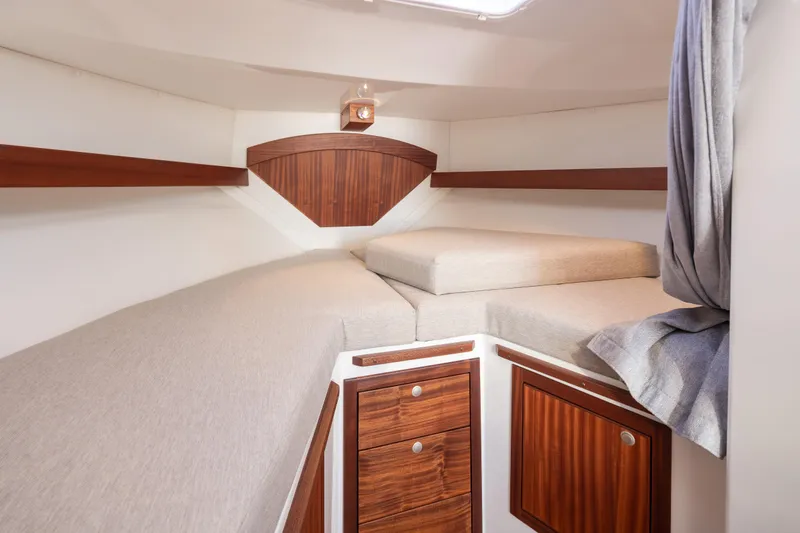 Slide: The Image of 2025 Ocean Sport Roamer cabin interior with wooden accents and beige cushions. - 34