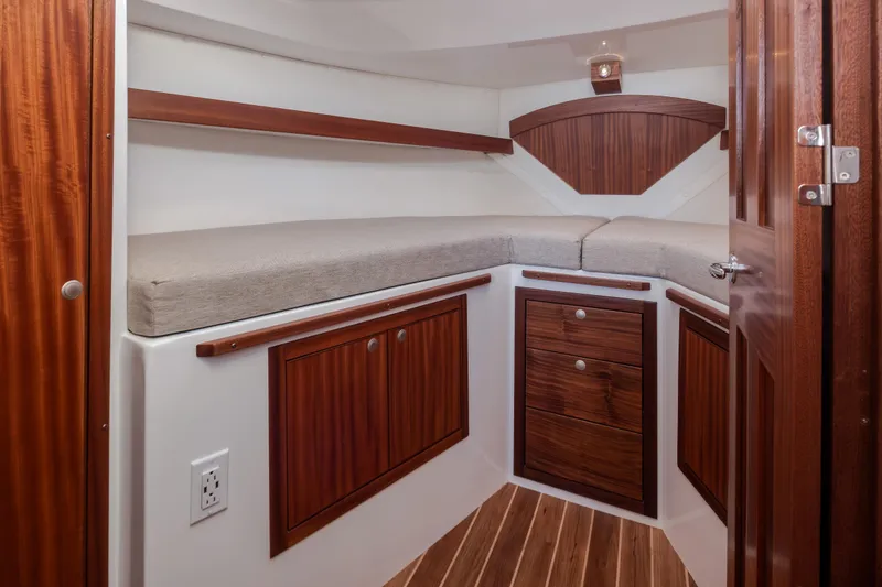 Slide: The Image of Luxurious 2025 Ocean Sport Roamer cabin interior with wooden cabinetry and cozy bedding. - 36