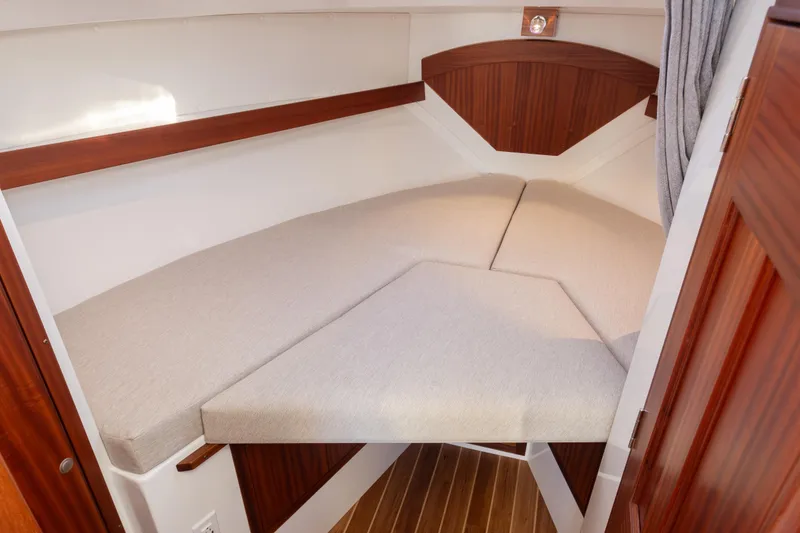 Slide: The Image of 2025 Ocean Sport Roamer cabin interior with wooden accents and cushioned seating. - 37