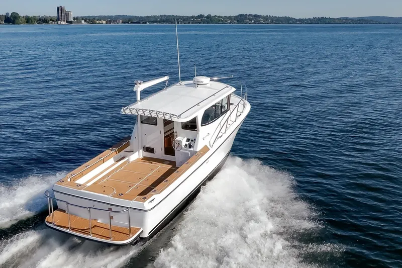 Slide: The Image of 2025 Ocean Sport Roamer cruising on a serene blue lake. - 4