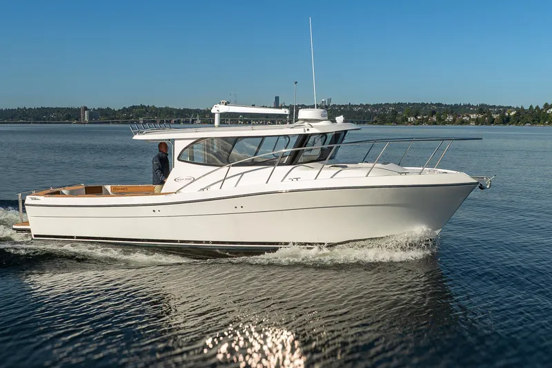 Slide: The Image of 2025 Ocean Sport Roamer cruising on a calm lake under a clear blue sky. - 5