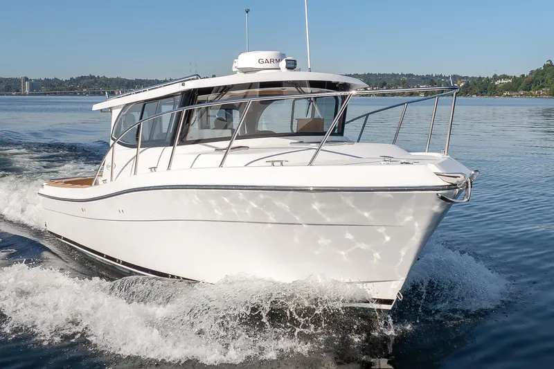 Slide: The Image of 2025 Ocean Sport Roamer cruising on a calm lake under clear blue skies. - 6