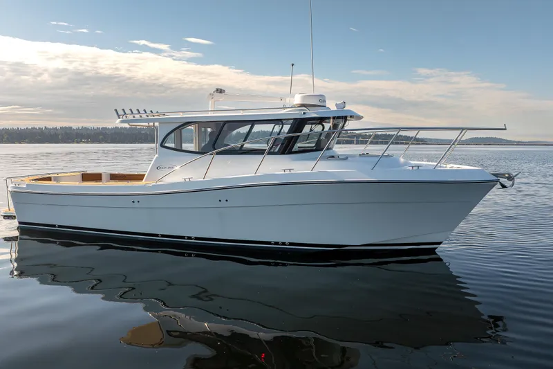 Slide: The Image of 2025 Ocean Sport Roamer boat on calm water under a partly cloudy sky. - 8