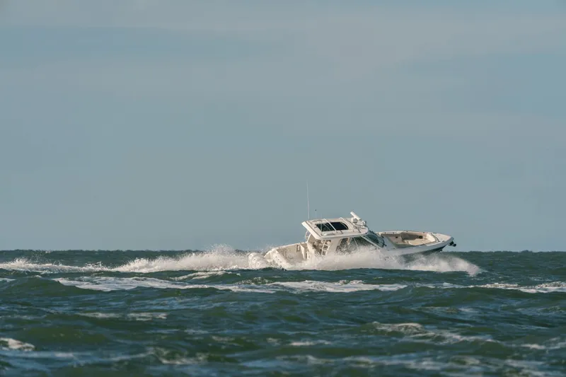 Slide: The Image of A 2027 Boston Whaler 380 Realm navigating through rough seas with splashing water. - 3
