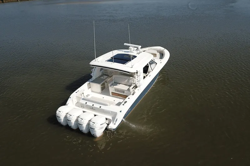 Slide: The Image of A sleek 2027 Boston Whaler 380 Realm boat with four outboard engines on calm water. - 36
