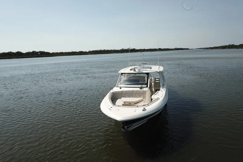 Slide: The Image of 2027 Boston Whaler 380 Realm on calm water, featuring a spacious deck and modern design. - 27
