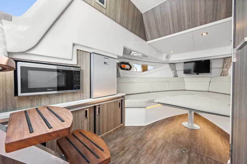 Slide: The Image of Interior of a modern yacht with wood paneling, seating area, TV, and microwave. - 43
